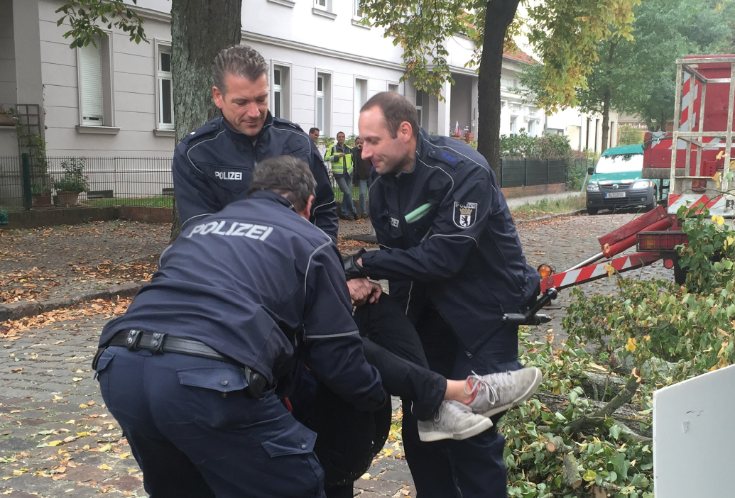 Polizisten tragen einen Baumschützer weg, der gegen die Fällung einer Linde in der Scharnweberstraße in Friedrichshagen protestierte