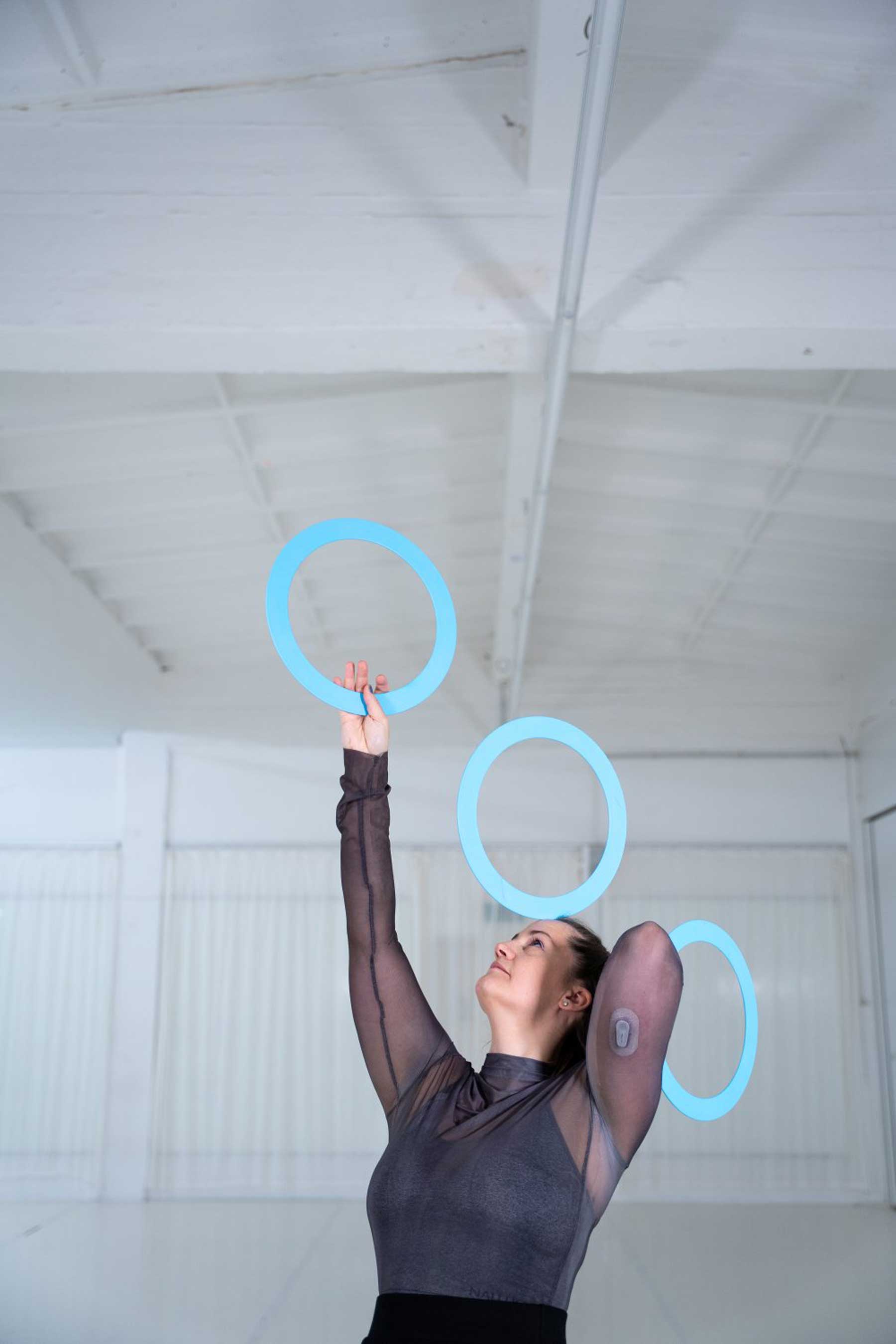 Die Zirkusartistin Kathrin Wagner jongliert mit blauen Ringen.
