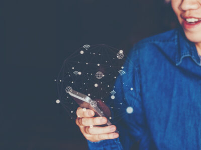 Dame im Jeanshemd am Smartphone mit ulkigen Icons