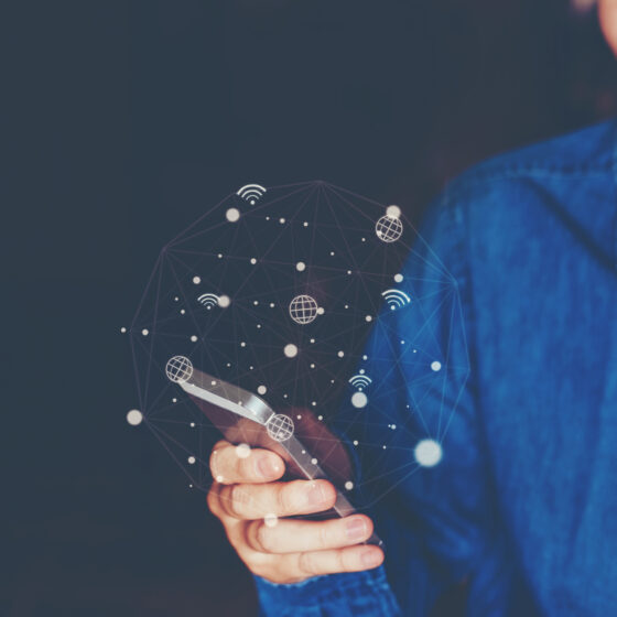 Dame im Jeanshemd am Smartphone mit ulkigen Icons