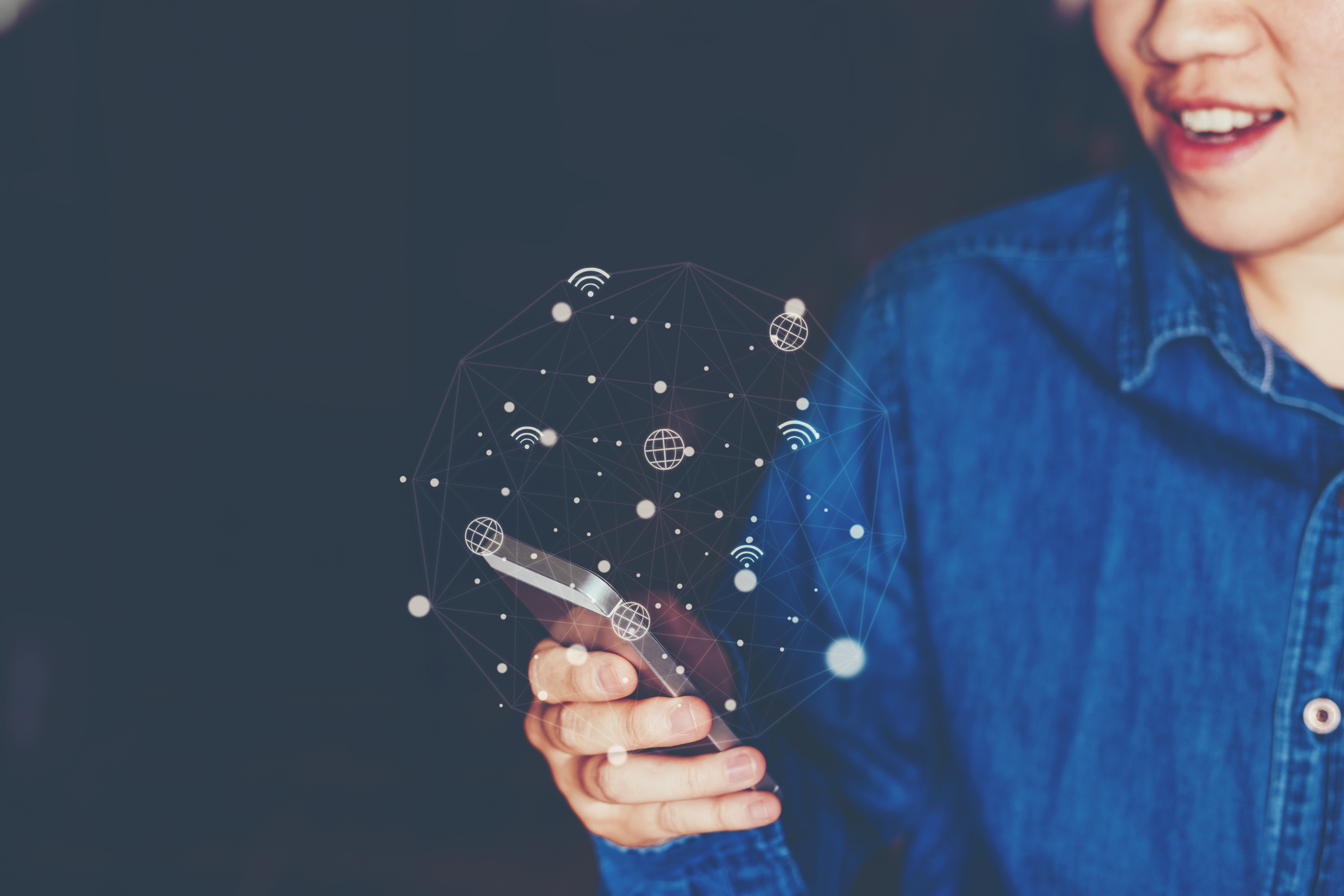 Dame im Jeanshemd am Smartphone mit ulkigen Icons