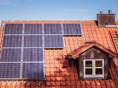 Solarpanels auf rotem Ziegeldach eines Einfamilienhauses
