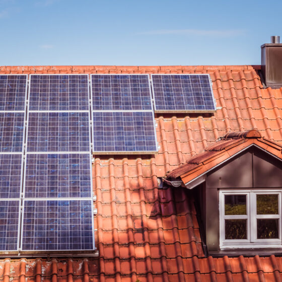 Solarpanels auf rotem Ziegeldach eines Einfamilienhauses